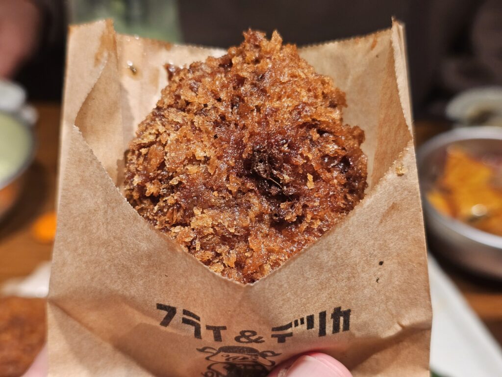 手に持った肉のウヱキのメンチカツ